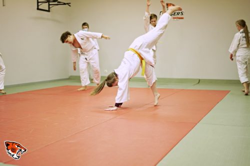 Młodzi judocy wykonujący gwiazdę (przerzut bokiem) na treningu judo w Strzelinie (Judo Tigers)