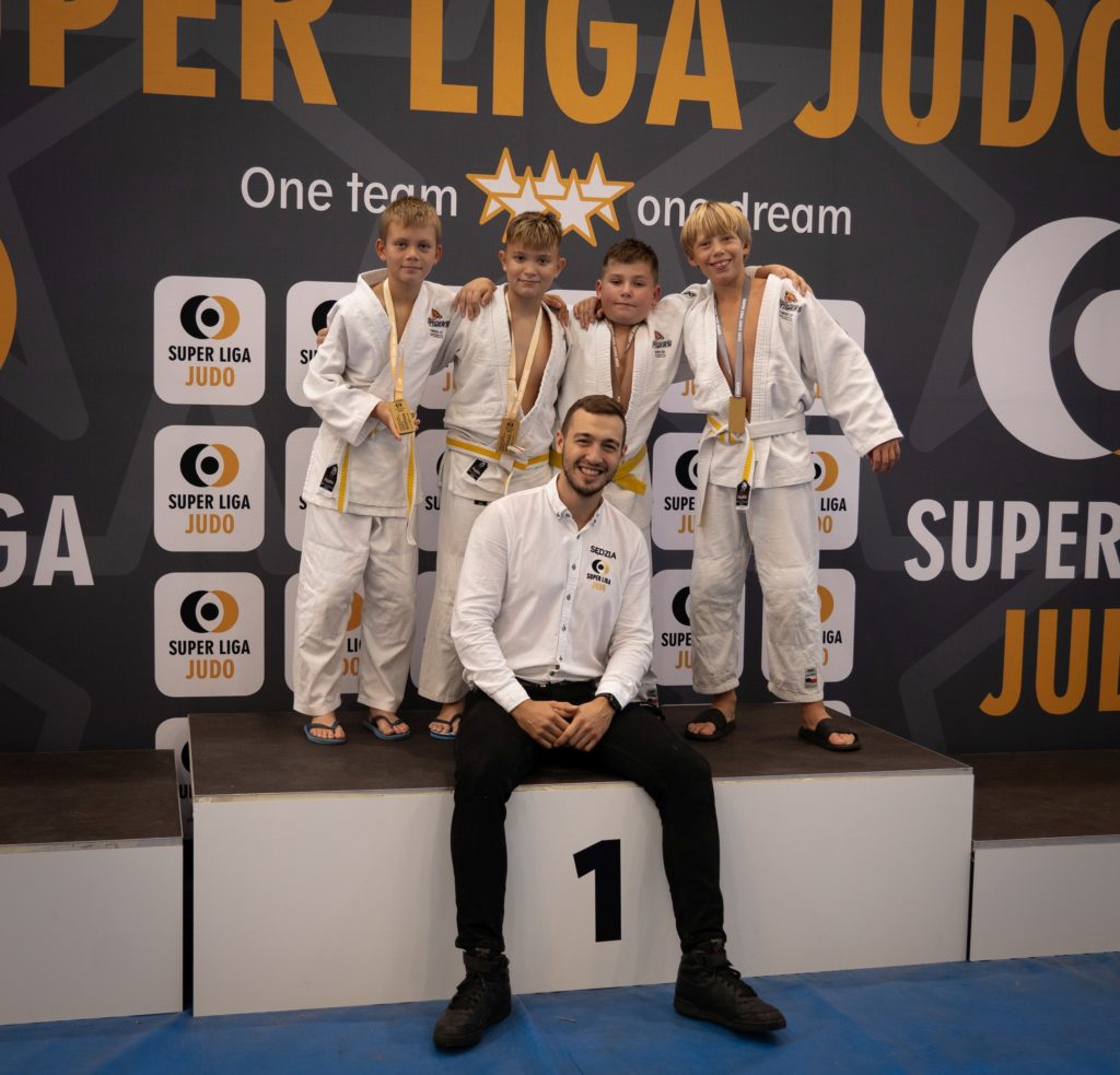 Trener judo Michał Cepuch ze swoimi zawodnikami na podium Super Ligi Judo
